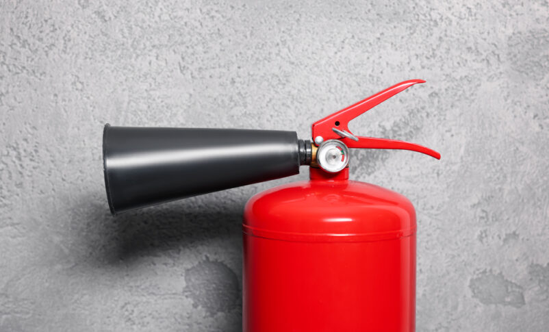 Rode brandblusser bij grijze muur